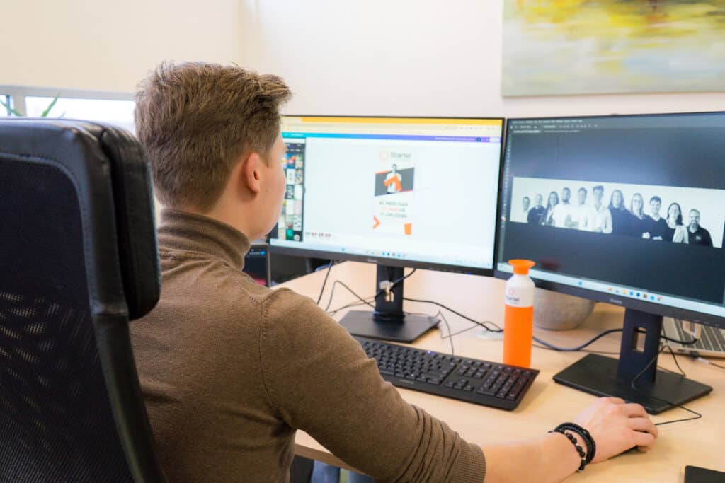 Foto van medewerker van Startel (Hylke Bosma) die aan zijn werkplek zit.