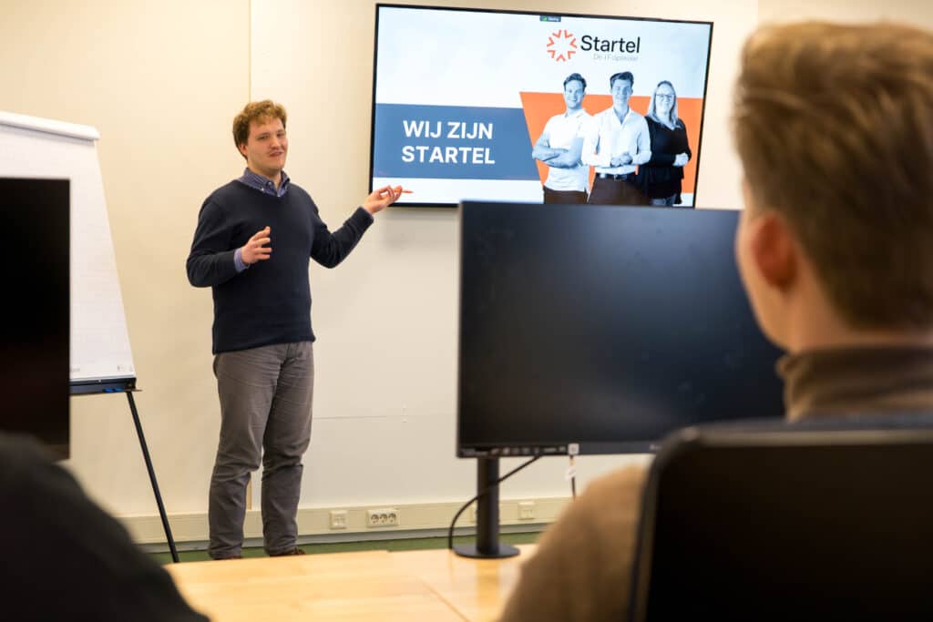 Een medewerker van Startel (Johannes van Oosterom) staat voor de klas.